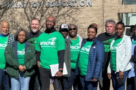 Photo of members of AFSCME Local 1899 in green shirts standing together in a group