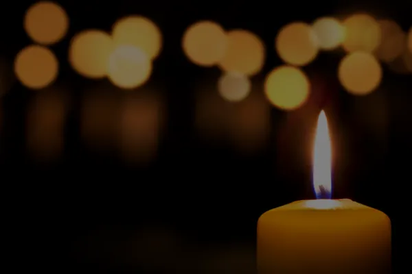 Lit candle against a black background