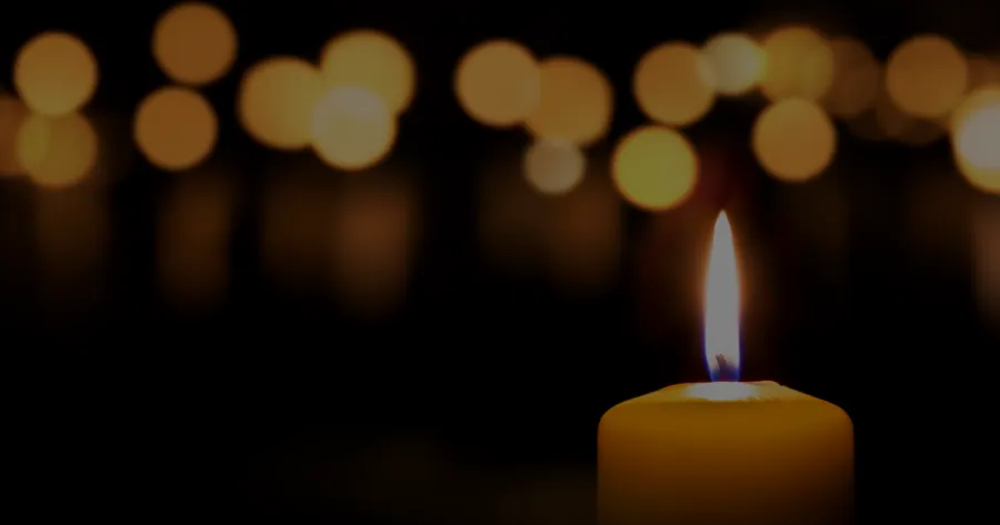 Lit candle against a black background